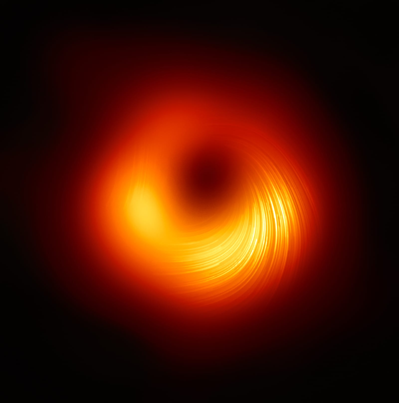 The polarized view of the M87* black hole, showing magnetic field lines as spiral streaks across the bright ring. The polarization reveals the magnetic field structure that may be responsible for launching M87's relativistic jet.