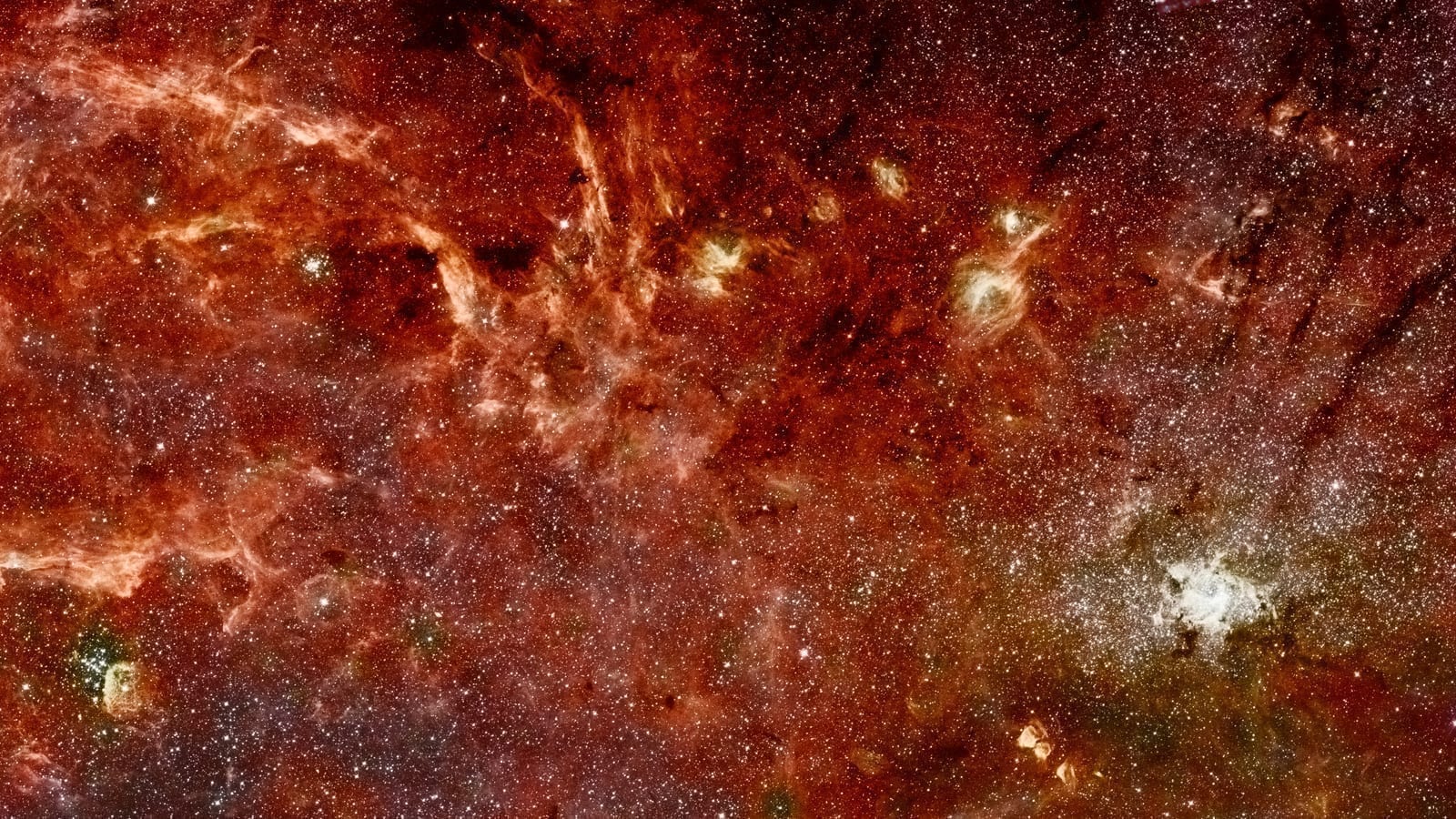 The center of the Milky Way in infrared, a mosaic built from Hubble and Spitzer observations, showing dense glowing gas, dust, and millions of stars around the galactic core. Credit: NASA, ESA and Q.D. Wang (University of Massachusetts, Amherst).