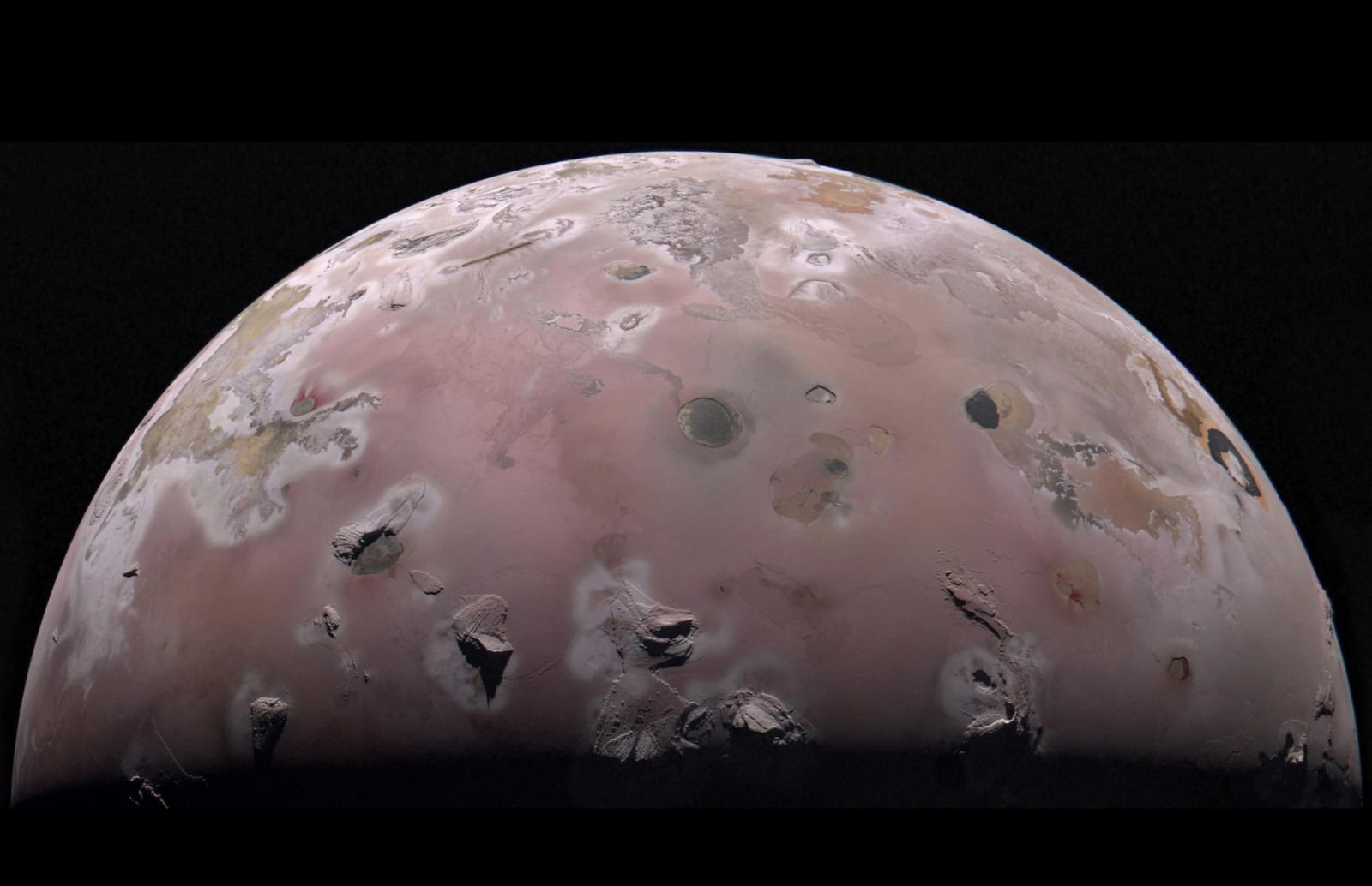 JunoCam image of Io's northern polar region, showing the moon's mottled surface of dark volcanic calderas, sulfur plains, and lava fields.