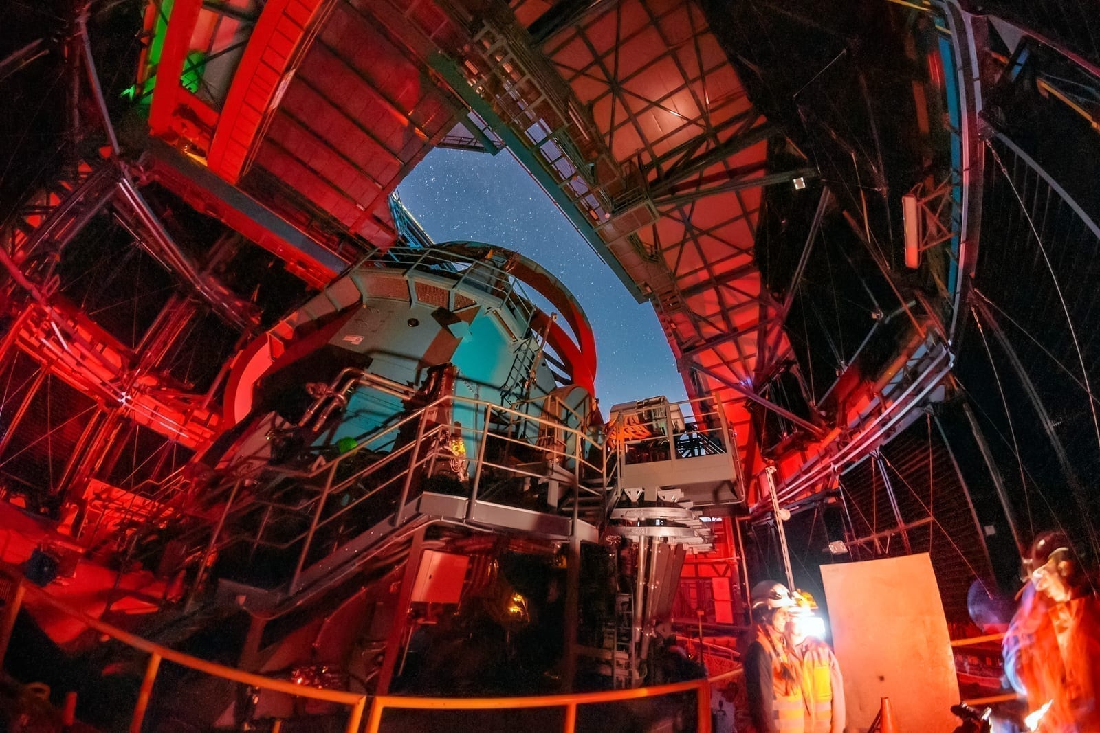 The Simonyi Survey Telescope at Rubin Observatory on Cerro Pachon in Chile, with the dome open to the night sky, as stars trail overhead in a long-exposure image