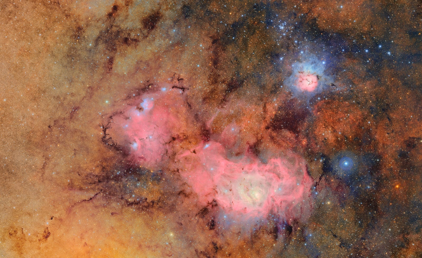 Deep Rubin Observatory image of the Trifid and Lagoon Nebulae, two iconic star-forming regions in the constellation Sagittarius, showing intricate clouds of glowing gas and dark dust lanes
